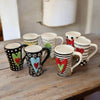 Unique, artful mugs with a cheery heart accent.